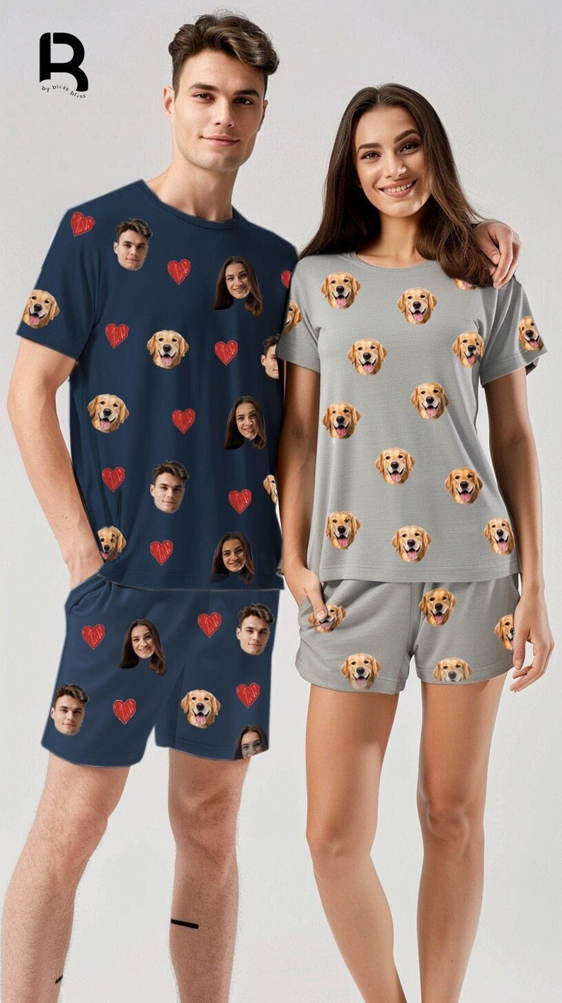 Pu&ograve; includere: Una coppia indossa pigiami abbinati con un motivo ripetuto di cuori rossi e volti di un cane golden retriever. L'uomo indossa una camicia a maniche corte blu navy e pantaloncini abbinati. La donna indossa una camicia a maniche corte grigio chiaro e pantaloncini abbinati.
