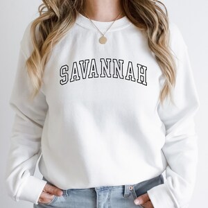 May include: White sweatshirt with black text that reads "SAVANNAH" in a collegiate font.