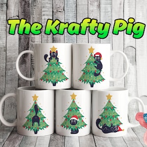 May include: White ceramic mugs with a Christmas tree and black cat design. The mugs feature a green Christmas tree decorated with red ornaments and a gold star. Some cats wear Santa hats. The text "The Krafty Pig" is at the top.
