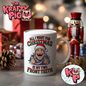 Pode incluir: Caneca de cerâmica branca com o texto "ALL I WANT FOR CHRISTMAS IS MY TWO FRONT TEETH" e uma imagem de desenho animado de um homem usando um gorro de Papai Noel e luzes de Natal. A caneca tem uma alça branca e é cercada por decorações de Natal.