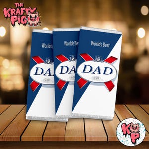 May include: Three chocolate bars with blue and white wrappers. The wrappers have a red diagonal stripe with a white oval in the center. The oval says "Worlds Best DAD".