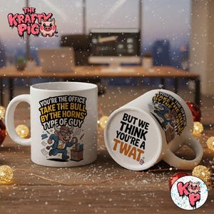 Pode incluir: Duas canecas de cerâmica branca com texto e ilustrações humorísticas. Uma caneca diz "You're the office take the bull by the horns type of guy" com um touro de desenho animado. A outra caneca diz "But we think you're a twat."