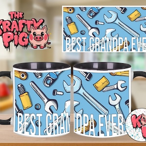 May include: A black-handled coffee mug with the words "BEST GRANDPA EVER" in white block letters. The mug features a light blue background with a pattern of wrenches, bolts, and other tools. The logo "The Krafty Pig" is visible.