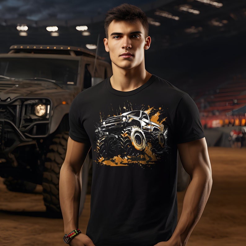 May include: A black t-shirt with a graphic of a black truck driving through mud. The truck has large tires and is covered in brown mud splatters.