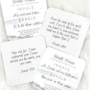 May include: Four square white cards featuring printed text and ocean imagery. The cards display religious verses and breath prayer prompts including Job 33:4, Psalm 61:2, and Isaiah 43:1. The text is written in a mix of serif and script fonts in black.