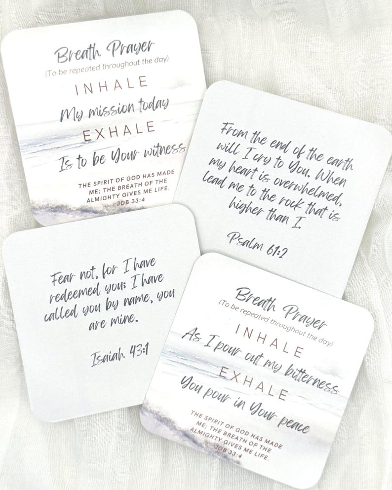 May include: Four square white cards featuring printed text and ocean imagery. The cards display religious verses and breath prayer prompts including Job 33:4, Psalm 61:2, and Isaiah 43:1. The text is written in a mix of serif and script fonts in black.