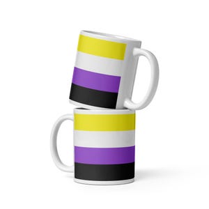 Peut inclure: Deux tasses en céramique blanche empilées l'une sur l'autre. Les tasses présentent un motif rayé jaune, blanc, violet et noir.