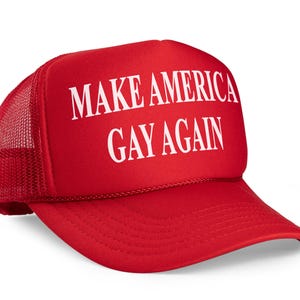 May include: Red mesh trucker hat with the text "Make America Gay Again" in white letters.