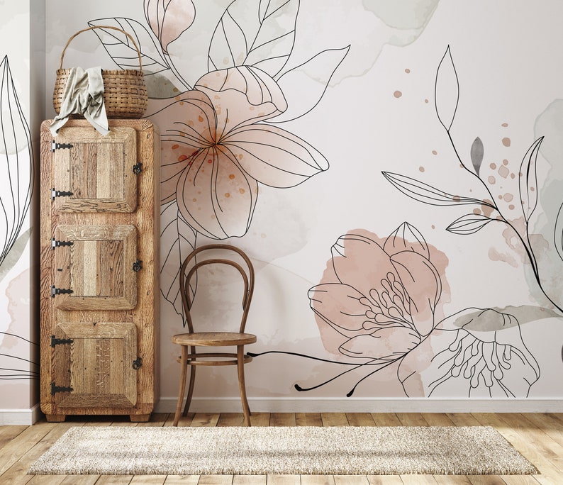 Pu&ograve; includere: Un armadio in legno con tre ante e una sedia di fronte. La parete dietro l'armadio e la sedia &egrave; decorata con una carta da parati floreale con accenti acquerellati rosa e grigi.