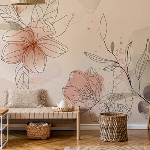 Pu&ograve; includere: Una stanza beige chiaro con una carta da parati floreale con accenti acquerellati rosa e verdi. Una panca di legno con un cesto intrecciato si trova di fronte al muro. Un cesto intrecciato si trova sul pavimento accanto alla panca. Uno scaffale di legno con un cesto intrecciato e una candela bianca si trova nell'angolo della stanza.