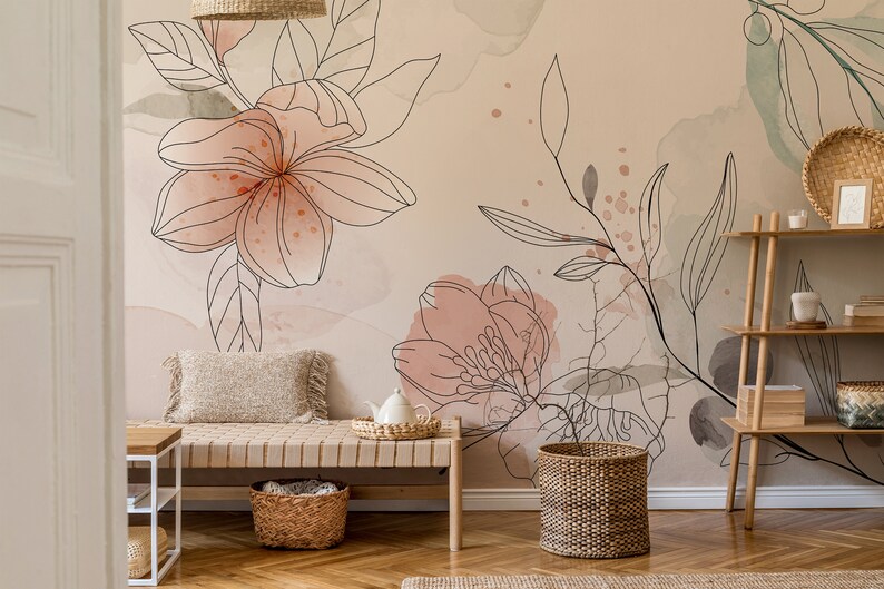 Pu&ograve; includere: Una stanza beige chiaro con una carta da parati floreale con accenti acquerellati rosa e verdi. Una panca di legno con un cesto intrecciato si trova di fronte al muro. Un cesto intrecciato si trova sul pavimento accanto alla panca. Uno scaffale di legno con un cesto intrecciato e una candela bianca si trova nell'angolo della stanza.