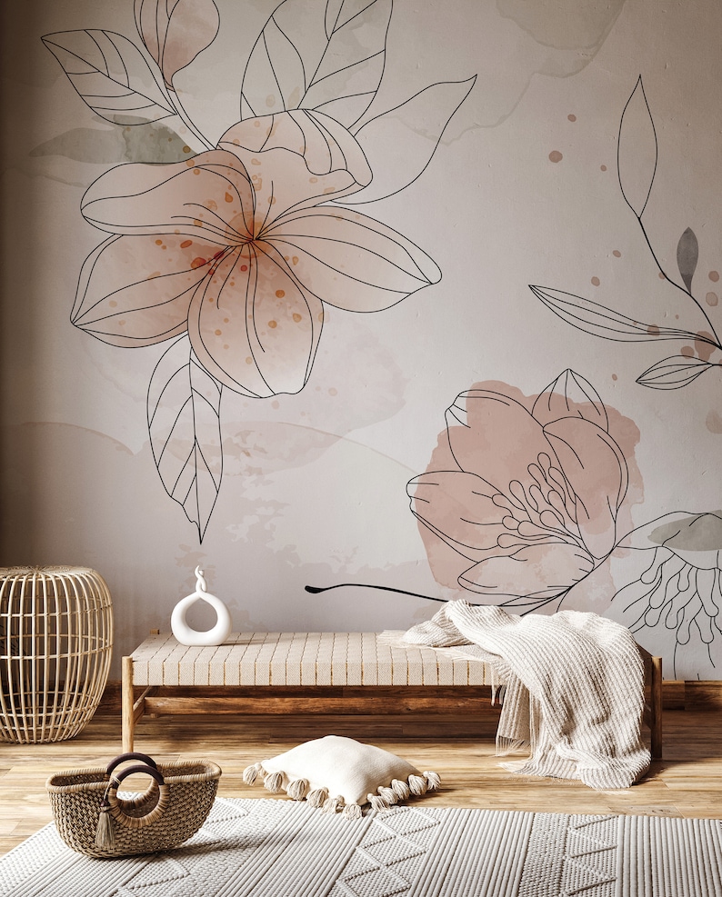 Pu&ograve; includere: Una panca in legno marrone chiaro con una coperta bianca drappeggiata sullo schienale. La panca &egrave; davanti a un muro con un design floreale con fiori e foglie rosa e bianche.