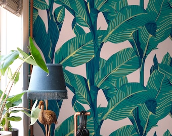 May include: A DJ setup with two turntables and a mixer in front of a wall with a tropical leaf wallpaper. A disco ball hangs from the ceiling and a gold flamingo figurine sits on a table next to a blue lamp.