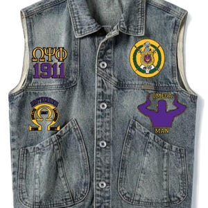 May include: A denim vest with four patches. The patches feature Greek letters and the words "OMEGA MAN" and "BROTHERHOOD". The vest has two front pockets and a button-up closure. The vest is a faded blue color.