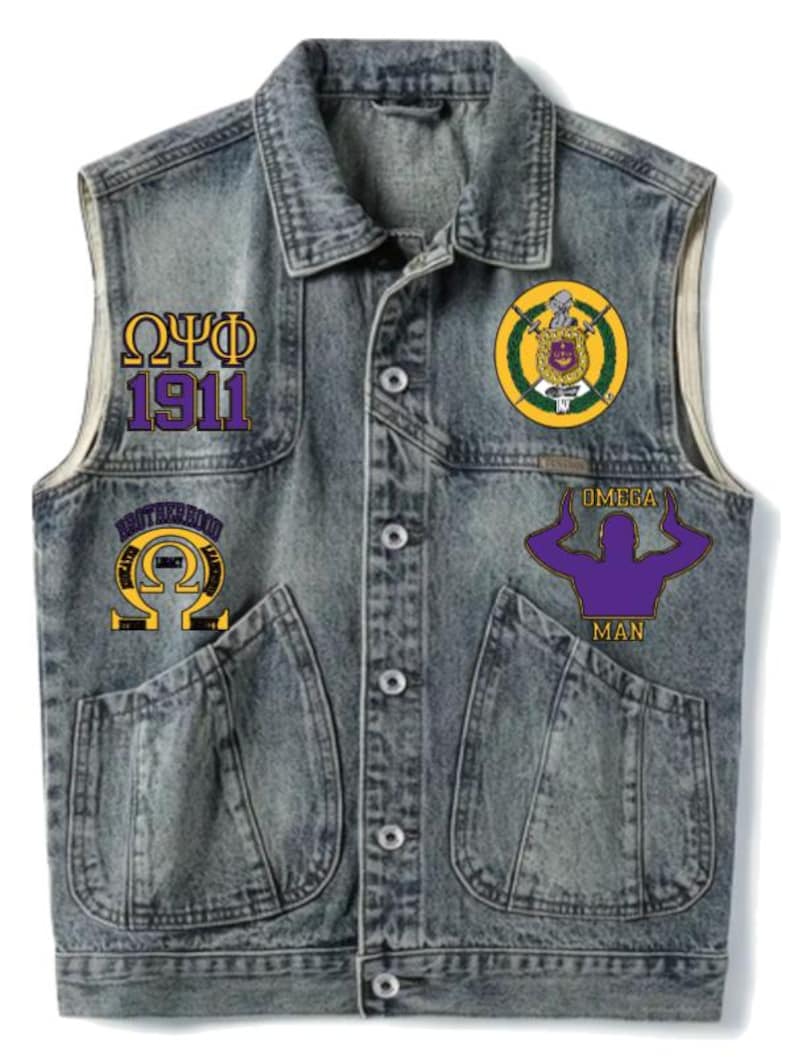 May include: A denim vest with four patches. The patches feature Greek letters and the words "OMEGA MAN" and "BROTHERHOOD". The vest has two front pockets and a button-up closure. The vest is a faded blue color.