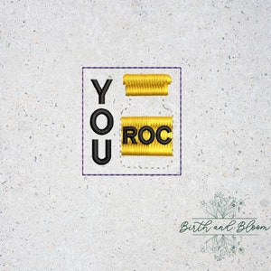May include: Embroidered patch with the words "YOU ROC" in black text on a yellow background. The letters are arranged in a vertical column.