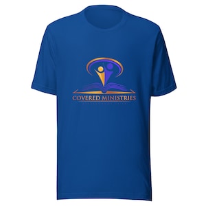 May include: A royal blue t-shirt with a gold and purple logo. The logo features a book with two people standing on top of it. The text "COVERED MINISTRIES" is below the logo.