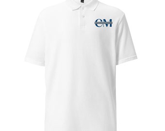 Puede incluir: Camiseta polo blanca con un logotipo bordado en azul que dice "CM" en el pecho izquierdo.