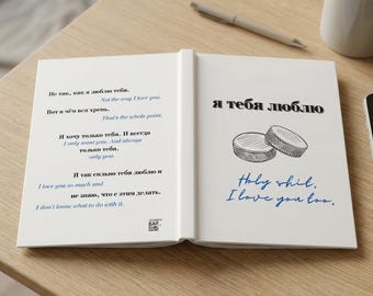 Könnte beinhalten: Ein aufgeschlagenes Buch mit weißen Seiten, das schwarzen und blauen Text auf Russisch und Englisch enthält. Die linke Seite zeigt poetische Zeilen, während auf der rechten Seite "я тебя люблю" über einer Skizze von zwei Eishockey-Pucks und "Holy shit. I love you too." steht.