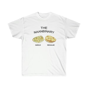 Può includere: Maglietta bianca con il testo "THE NAANBINARY" e due immagini di pane naan, una etichettata "GARLIC" e l'altra "REGULAR".