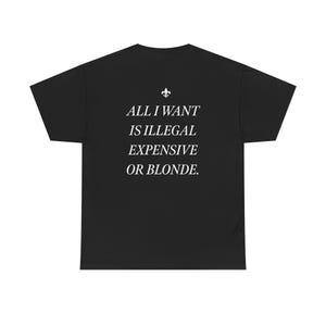 May include: Black t-shirt with white text that reads "ALL I WANT IS ILLEGAL EXPENSIVE OR BLONDE." A fleur-de-lis symbol is above the text. The shirt is a casual wear item.