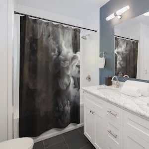 May include: A black and white shower curtain featuring a swirling smoke design. The curtain is hanging in a bathroom with a white vanity and a mirror.