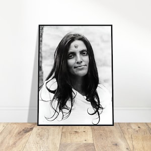 Puede incluir: Fotografía en blanco y negro de una mujer con el pelo largo y oscuro. Lleva una camisa blanca y tiene un pequeño punto rojo en la frente.