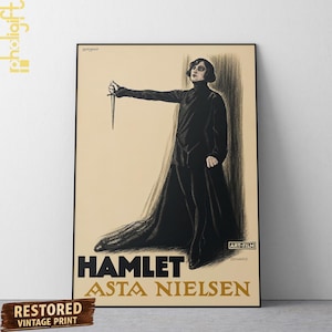 May include: A vintage film poster for Hamlet featuring Asta Nielsen. The illustration depicts a figure in a long black coat and dark leggings, holding a dagger outstretched. The background is a light beige, with the text HAMLET and ASTA NIELSEN.