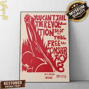 May include: A rectangular poster featuring a red graphic of a raised fist and a person's head against a cream background. The text reads: YOU CAN'T JAIL THE REVOLUTION STOP THE TRIAL FREE THE CONSPIRACY 8 28 E JACKSON CHICAGO 427-7773.