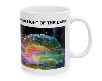 May include: White ceramic mug with a digital illustration of a brain in vibrant colours. The brain graphic is in shades of green, yellow, orange, and purple, with the text "MAKING LIGHT OF THE DARK" above the graphic. The mug has a standard handle.