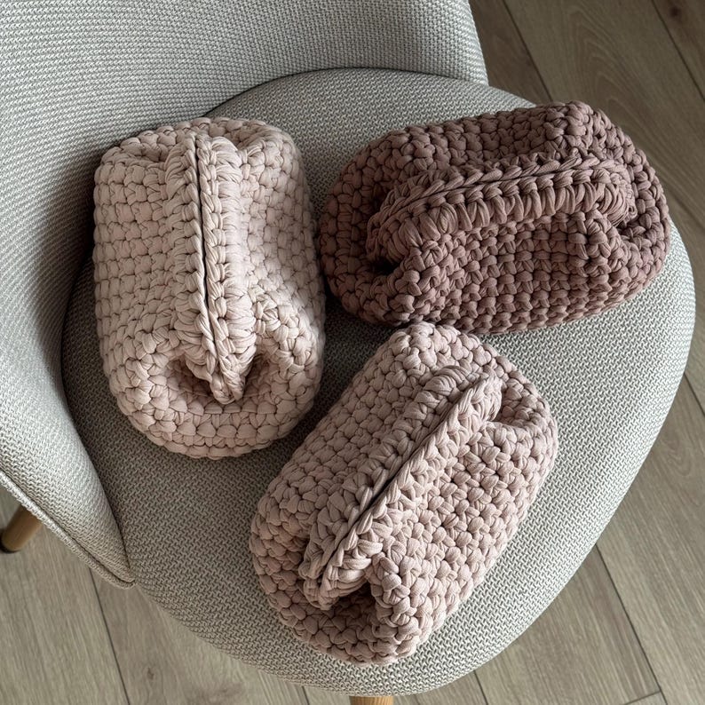 Set of crochet cosmetic pouches in neutral pastel colors, modern handmade organizer bags with textured stitches.