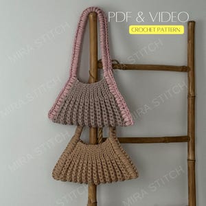 May include: Two handmade crochet bags in the image. The top bag is taupe with a pink handle and trim. The bottom bag is tan. The bags are displayed on a wooden ladder. The text "PDF & VIDEO CROCHET PATTERN" is in the upper right corner.