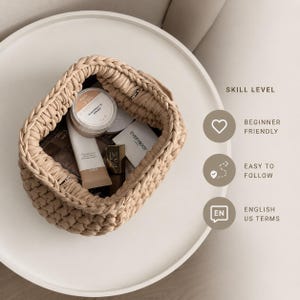 Open crochet pouch shown from above with a dark interior and small items placed inside.
