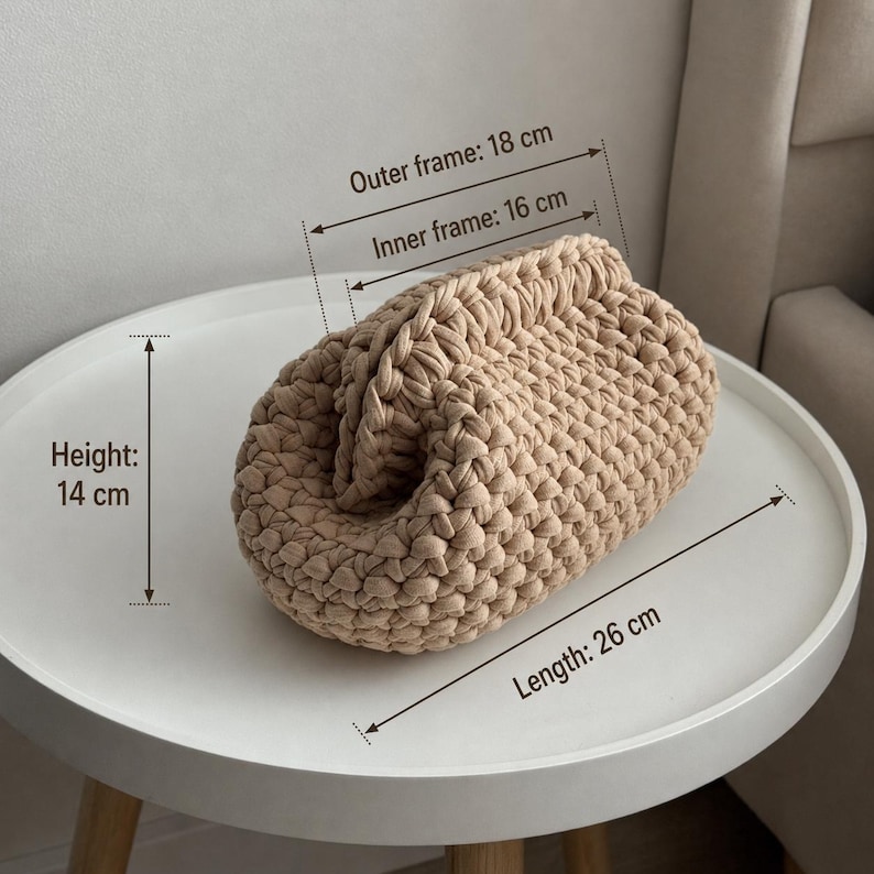 Finished chunky crochet pouch with measurement lines showing the size on a round white table.