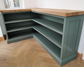 May include: A corner shelf unit with a wooden top and green painted shelves. The shelves are open and have a simple design.
