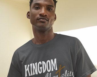 Könnte beinhalten: Ein dunkelgraues T-Shirt mit dem Text "KINGDOM Mentality" in weißen Buchstaben und einer braunen Kreuzgrafik.