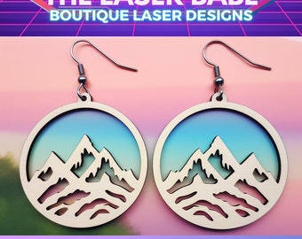 May include: A pair of wooden earrings with a mountain range design. The earrings are painted with a gradient of blue, green, and pink colors. The earrings are called "Mountain Range Dangles".