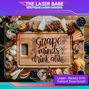 Pode incluir: Uma tábua de cortar de madeira com o texto "Grape minds drink alike" gravado nela. A tábua é cercada por vários alimentos, como queijo, bolachas, uvas e azeitonas.