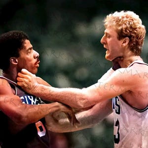 May include: A vintage photograph captures two basketball players in a tense moment. One player, wearing a white jersey with the number 3, appears to be confronting another player in a dark jersey with the number 0. The image is a classic sports moment.