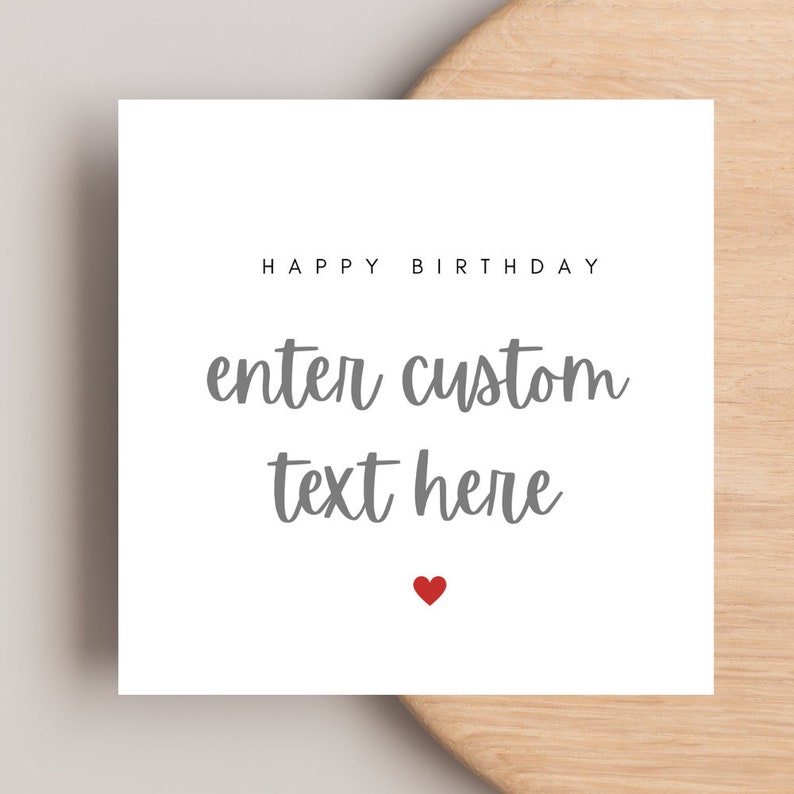Op de afbeelding: Een vierkante witte kaart met de zwarte tekst HAPPY BIRTHDAY bovenaan, gevolgd door de grijze cursieve tekst enter custom text here, en een klein rood hartje onderaan in het midden van het kaartontwerp.