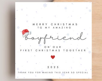 May include: A white Christmas card with a red Santa hat illustration. The card reads "Merry Christmas to my amazing boyfriend on our first Christmas together" with a red heart and the year 2025.