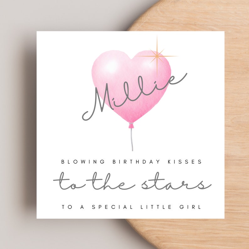 May include: A pink heart-shaped balloon with the name "Millie" written on it. The balloon is floating with a string attached to it. The text "Blowing birthday kisses to the stars to a special little girl" is written below the balloon.