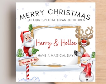 Op de afbeelding: Een vierkante kerstkaart met de kerstman, een rendier en een sneeuwpop. De tekst luidt: MERRY CHRISTMAS TO OUR SPECIAL GRANDCHILDREN, Harry & Hollie, HAVE A MAGICAL DAY! Een North Pole wegwijzer staat aan de linkerkant in de sneeuw.