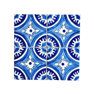 May include: Four blue and white ceramic tiles with a geometric pattern. The tiles have a repeating design of circles and stars.