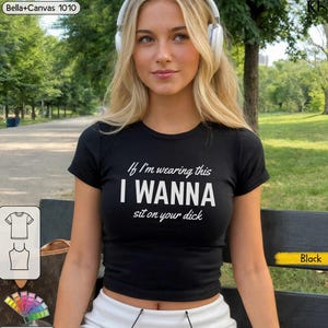 Könnte beinhalten: Ein schwarzes kurzärmeliges T-Shirt mit dem weißen Aufdruck If I'm wearing this I WANNA sit on your dick. Das Kleidungsstück ist ein Bella+Canvas 1010 Modell, das mit einer figurbetonten Silhouette, einem Rundhalsausschnitt und schwarzem Stoff gestaltet ist.