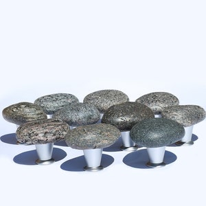 Könnte beinhalten: Ein Satz von zehn runden Stein-Schrankknöpfen mit silbernen Sockeln. Die Knöpfe sind in verschiedenen Grautönen und Braun.