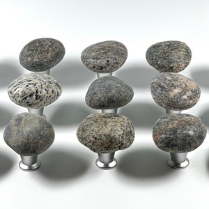 May include: A set of 10 stone knobs with a natural, speckled finish. Each knob is a unique shape and size, with a silver base.