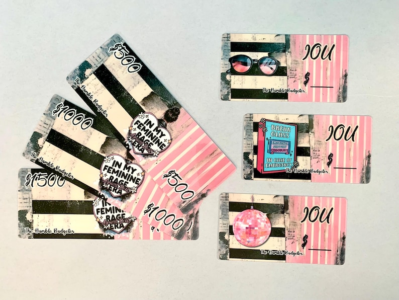 May include: A collection of pink and black graphic cards with text and illustrations. Some cards display dollar amounts, while others feature sunglasses, a disco ball, and the text "IN MY FEMININE RAGE ERA."