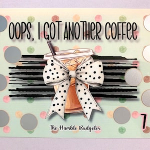 May include: A green and white card with a brown and white iced coffee illustration and a black and white bow. The card says "Oops, I got another coffee" and "The Humble Budgeter". There are 15 silver circles on the card.
