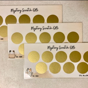 May include: Three white cards with the text "Mystery Scratch Offs" printed in black. Each card has eight gold circles with a scratch-off coating. The cards have different amounts printed on them: $1-$30, $1-$20, and $1-$10.
